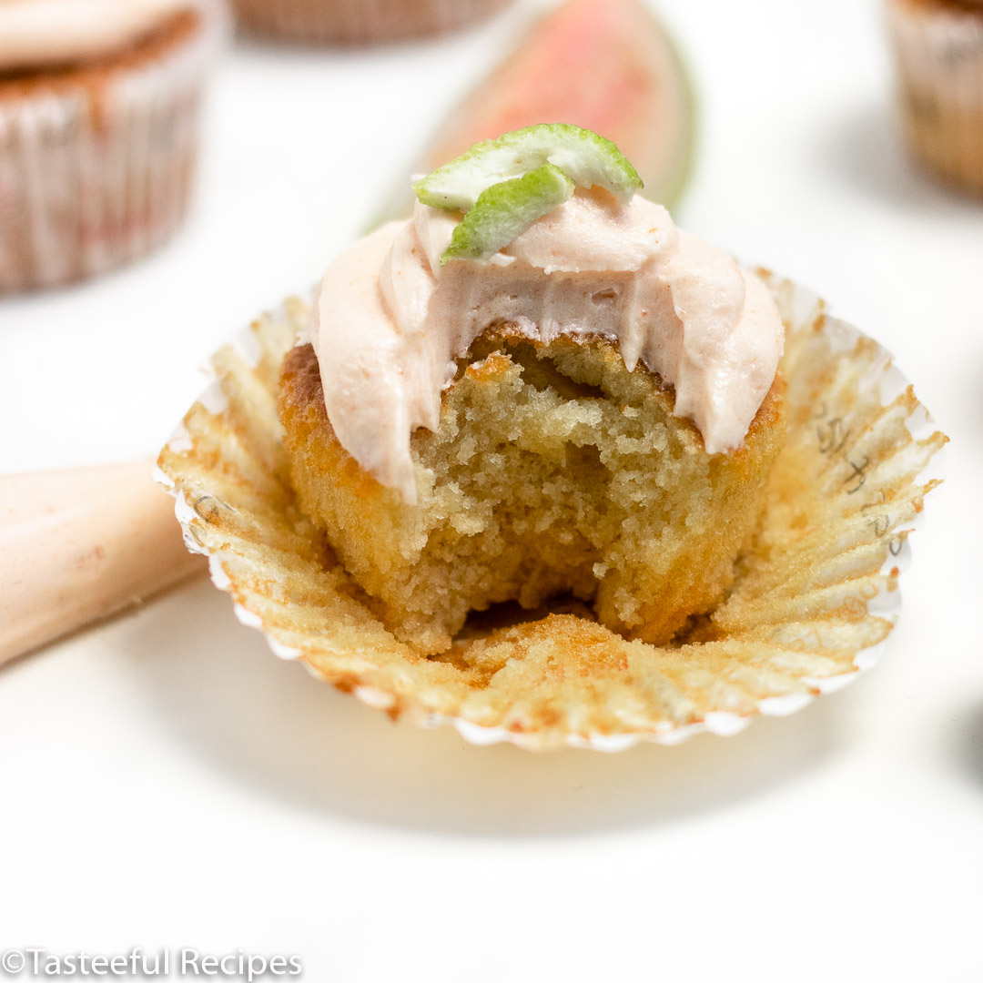 Straight on shot of a vanilla guava cupcakes that has been bitten into 