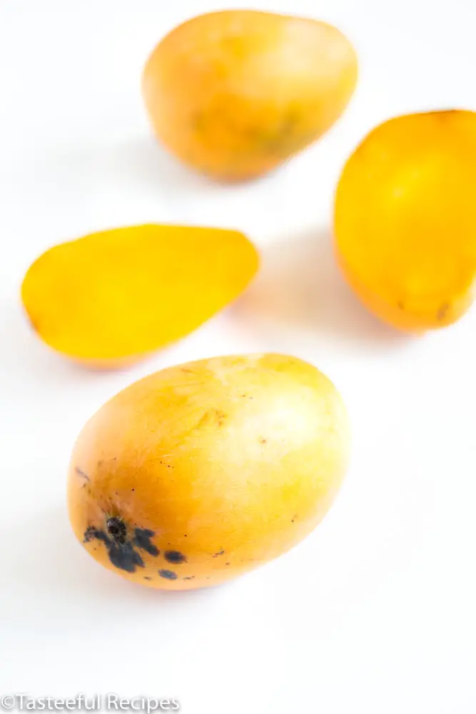 Straight on shot of mangoes on a white surface