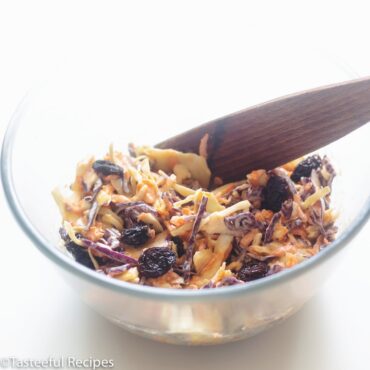 Angled shot of a bowl of Caribbean coleslaw being mixed together