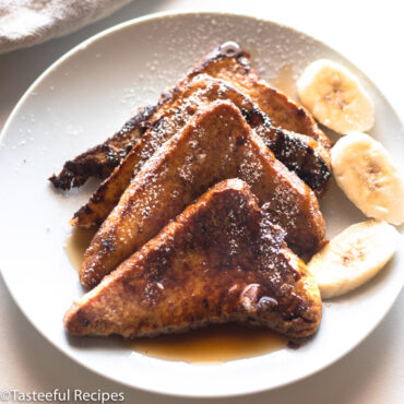 Angled shot of a plate of Caribbean stylre banana bread French toast